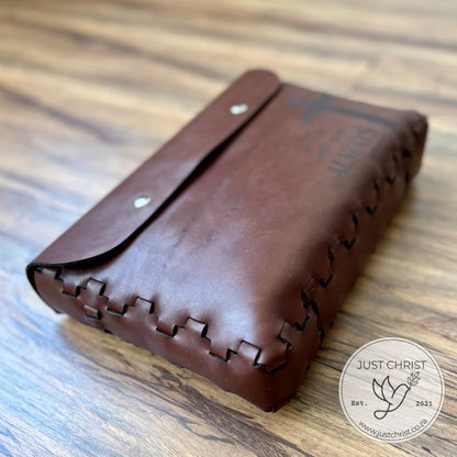 A red brown leather Bible Cover is shown, the cover is without a strap and has the lace effect.