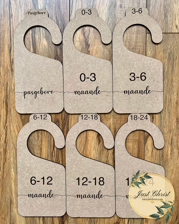 MDF wood closet dividers are placed on laminated wood flooring, month categories are engraved in Afrikaans on the closet dividers, eg. "pasgebore", "0-3 maande", "3-6 maande".