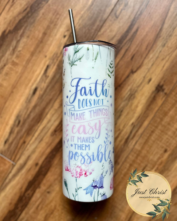 A stainless steel tumbler bottle and a stainless steel straw is placed on a wooden floor. The tumbler bottle is decorated with a flowerly wrap and the following statement: "faith does not make things easy, it makes them possible." 